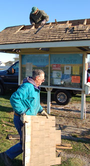 Frank Heller hauls away a piece of the kiosk roof