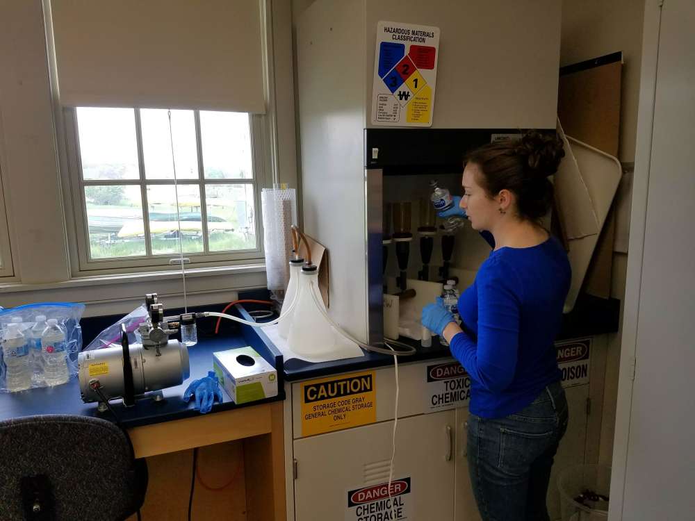 Research assistant Claire Gottsegen prepares to filter eDNA samples in a sterilized fume hood.