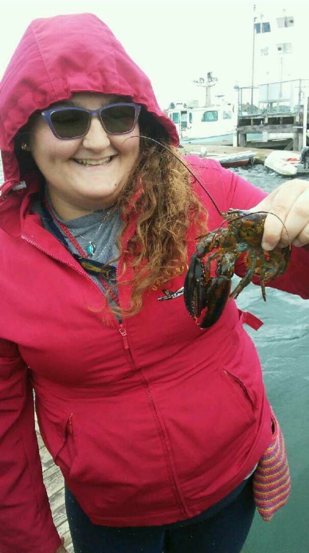 Research intern Blair Morrison holds a lobster.