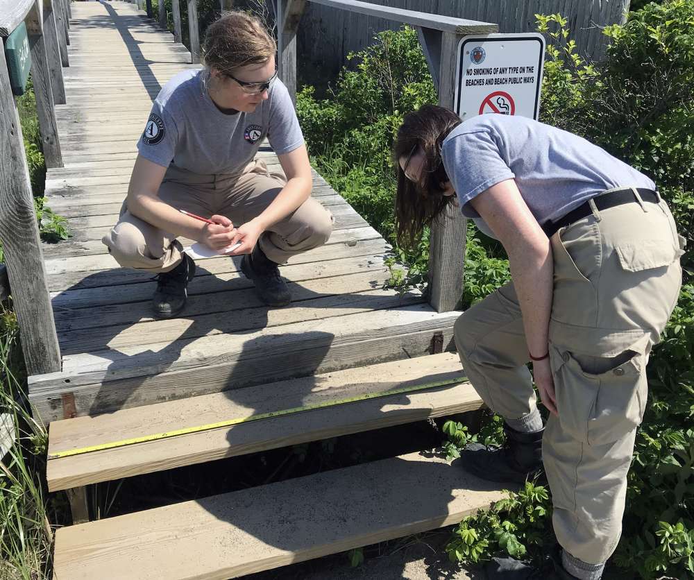 AmeriCorps volunteers measure steps on the beach access boardwalk.
