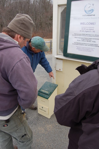 Putting on the finishing touch; attaching the donation box