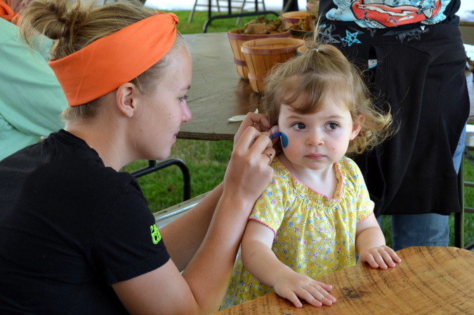 A face painter at work on a cutie