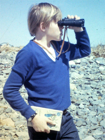 A young me on a Kennebunk beach with binoculars and field guide.